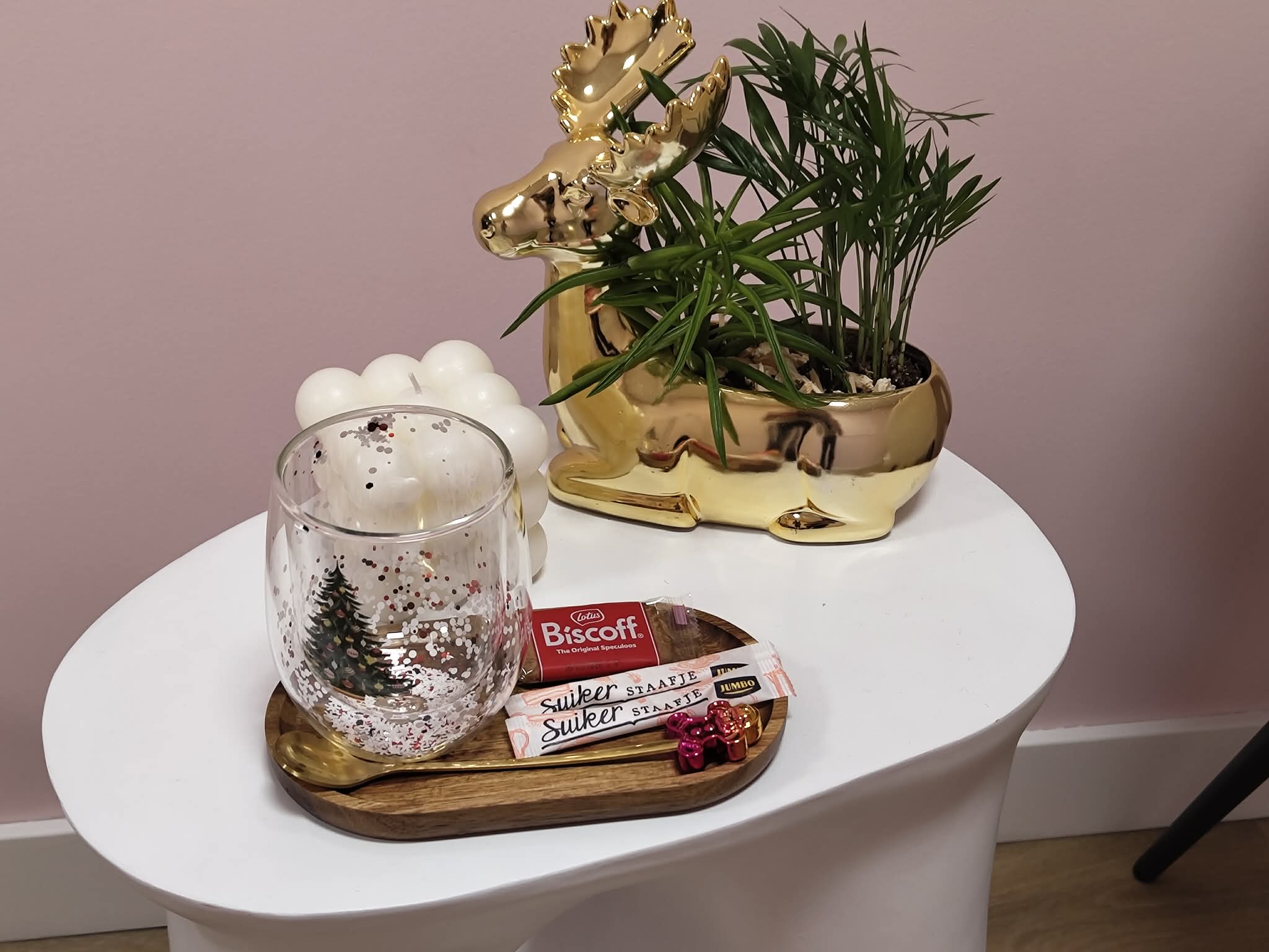 Bijzettafel in de salon met een theeglas, koekjes en een plant